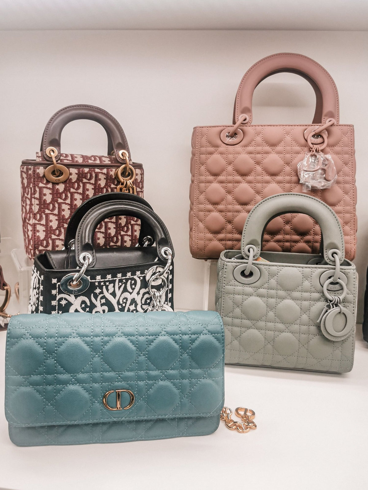 A curated group of designer handbags in soft pastel colours